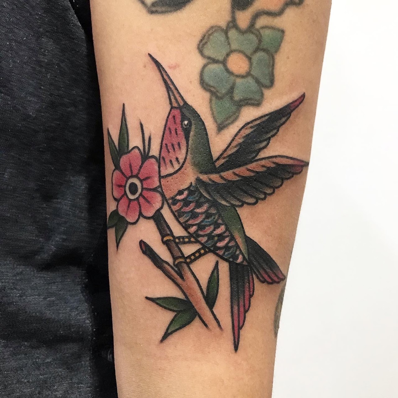 Tatuaje tradicional a color de colibrí sobre antebrazo, trabajo realizado en Cristian elmasa